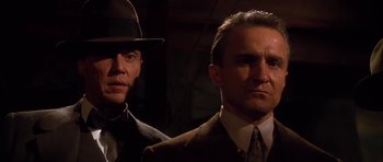 Movie still from “Last Man Standing” (1996), directed by Walter Hill – A man in a suit and a hat standing next to another man in a suit and a hat; Close Up shot, Low angle