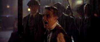 Movie still from “Last Man Standing” (1996), directed by Walter Hill – A man in a suit and tie with his mouth wide open in the rain; Close Up shot, Low angle