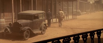 Movie still from “Last Man Standing” (1996), directed by Walter Hill – Two men walking down a dirt road near a car; Wide shot, High angle
