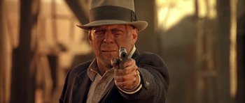 Movie still from “Last Man Standing” (1996), directed by Walter Hill – An older man in a hat and a suit points a gun; Close Up shot, Low angle