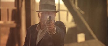 Movie still from “Last Man Standing” (1996), directed by Walter Hill – A man wearing a hat and holding a gun in his hand; Close Up shot, Low angle