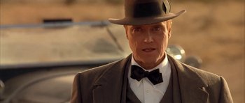 Movie still from “Last Man Standing” (1996), directed by Walter Hill – A person wearing a suit and a hat; Close Up shot, Low angle