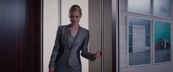 Movie still from “Fifty Shades of Grey” (2015), directed by Sam Taylor-Johnson – A woman in a gray suit standing in front of a mirror; Medium shot, Low angle