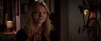 Movie still from “Fifty Shades of Grey” (2015), directed by Sam Taylor-Johnson – A woman with long blonde hair is smiling for the camera; Close Up shot, Over the shoulder angle