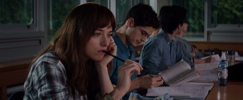 Movie still from “Fifty Shades of Grey” (2015), directed by Sam Taylor-Johnson – Three people sitting at a table with pens in their mouths; Close Up shot, Over the shoulder angle