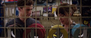 Movie still from “Fifty Shades of Grey” (2015), directed by Sam Taylor-Johnson – A man and a woman looking at each other through a fence; Close Up shot, Over the shoulder angle