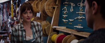 Movie still from “Fifty Shades of Grey” (2015), directed by Sam Taylor-Johnson – A woman standing in front of a rack of ropes; Close Up shot, Over the shoulder angle