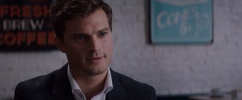 Movie still from “Fifty Shades of Grey” (2015), directed by Sam Taylor-Johnson – A person wearing a suit and tie; Close Up shot, Over the shoulder angle