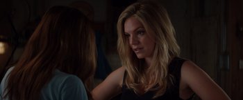 Movie still from “Fifty Shades of Grey” (2015), directed by Sam Taylor-Johnson – A woman with long blonde hair looking at another woman; Close Up shot, Over the shoulder angle