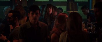 Movie still from “Fifty Shades of Grey” (2015), directed by Sam Taylor-Johnson – A group of people standing in a dark room; Medium shot, Over the shoulder angle