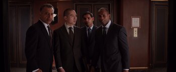 Movie still from “Fifty Shades of Grey” (2015), directed by Sam Taylor-Johnson – A group of men standing next to each other in suits; Medium shot, High angle