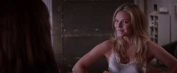 Movie still from “Fifty Shades of Grey” (2015), directed by Sam Taylor-Johnson – A beautiful blonde woman sitting in a chair; Close Up shot, Over the shoulder angle