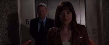 Movie still from “Fifty Shades of Grey” (2015), directed by Sam Taylor-Johnson – A man and a woman standing next to each other; Medium shot, Over the shoulder angle