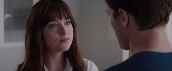 Movie still from “Fifty Shades of Grey” (2015), directed by Sam Taylor-Johnson – A young woman and a young man are looking at one another; Close Up shot, Over the shoulder angle