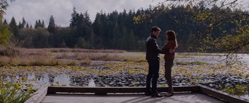Movie still from “Fifty Shades of Grey” (2015), directed by Sam Taylor-Johnson – A man and a woman standing next to a body of water; Wide shot, Over the shoulder angle