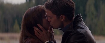 Movie still from “Fifty Shades of Grey” (2015), directed by Sam Taylor-Johnson – A man and a woman kissing each other; Close Up shot, Over the shoulder angle