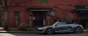 Movie still from “Fifty Shades of Grey” (2015), directed by Sam Taylor-Johnson – A car parked in front of a red brick building; Wide shot, High angle