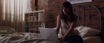 Movie still from “Fifty Shades of Grey” (2015), directed by Sam Taylor-Johnson – A woman sitting in front of an open laptop computer; Medium shot, High angle