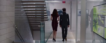 Movie still from “Fifty Shades of Grey” (2015), directed by Sam Taylor-Johnson – A man and a woman are walking down the stairs; Wide shot, High angle