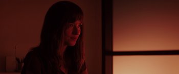 Movie still from “Fifty Shades of Grey” (2015), directed by Sam Taylor-Johnson – A woman with long brown hair is in the dark; Close Up shot, Over the shoulder angle