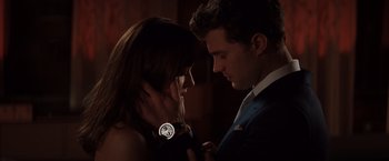 Movie still from “Fifty Shades of Grey” (2015), directed by Sam Taylor-Johnson – A man and a woman looking at each other in the dark; Close Up shot, Over the shoulder angle
