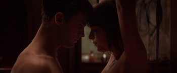 Movie still from “Fifty Shades of Grey” (2015), directed by Sam Taylor-Johnson – A man and a woman face to face in the dark; Close Up shot, Over the shoulder angle