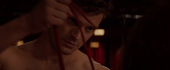 Movie still from “Fifty Shades of Grey” (2015), directed by Sam Taylor-Johnson – A person holding a red stick; Close Up shot, Over the shoulder angle