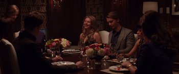 Movie still from “Fifty Shades of Grey” (2015), directed by Sam Taylor-Johnson – A group of people sitting around a table with plates of food; Medium shot, Over the shoulder angle