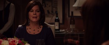 Movie still from “Fifty Shades of Grey” (2015), directed by Sam Taylor-Johnson – A woman sitting at a table with a glass of red wine; Close Up shot, Over the shoulder angle