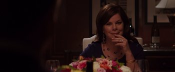 Movie still from “Fifty Shades of Grey” (2015), directed by Sam Taylor-Johnson – A woman sitting at a dinner table with flowers in front of her; Close Up shot, Over the shoulder angle