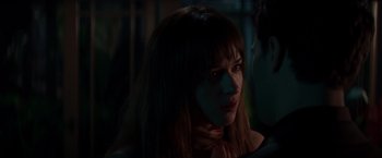 Movie still from “Fifty Shades of Grey” (2015), directed by Sam Taylor-Johnson – A person with long brown hair; Close Up shot, Over the shoulder angle