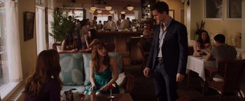 Movie still from “Fifty Shades of Grey” (2015), directed by Sam Taylor-Johnson – A man and a woman are sitting at a bar; Medium shot, Over the shoulder angle