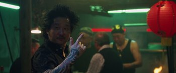 Movie still from “Keeping Up with the Joneses” (2016), directed by Greg Mottola – A man with a tattoo on his arm is pointing to the camera; Close Up shot, Over the shoulder angle