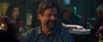 Movie still from “Keeping Up with the Joneses” (2016), directed by Greg Mottola – A person wearing a plaid shirt smiling; Close Up shot, Over the shoulder angle