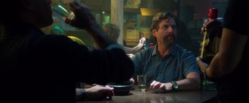 Movie still from “Keeping Up with the Joneses” (2016), directed by Greg Mottola – A group of people sitting at a table with food; Medium shot, Over the shoulder angle