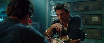 Movie still from “Keeping Up with the Joneses” (2016), directed by Greg Mottola – A man sitting at a table with a plate of food in front of him; Close Up shot, Over the shoulder angle