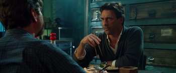 Movie still from “Keeping Up with the Joneses” (2016), directed by Greg Mottola – A man sitting at a table with chopsticks in front of a plate of food; Close Up shot, Over the shoulder angle