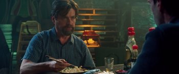 Movie still from “Keeping Up with the Joneses” (2016), directed by Greg Mottola – A man sitting at a table with a plate of food in front of him; Medium shot, Over the shoulder angle