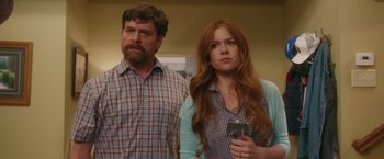 Movie still from “Keeping Up with the Joneses” (2016), directed by Greg Mottola – A man and a woman standing next to each other holding cell phones; Medium shot, Over the shoulder angle