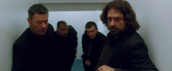 Movie still from “Keeping Up with the Joneses” (2016), directed by Greg Mottola – A group of men standing next to each other in a room; Medium shot, Low angle