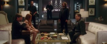 Movie still from “Keeping Up with the Joneses” (2016), directed by Greg Mottola – A group of people standing around a table; Wide shot, Over the shoulder angle