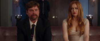 Movie still from “Keeping Up with the Joneses” (2016), directed by Greg Mottola – A man and a woman sitting next to each other in a room; Medium shot, Over the shoulder angle