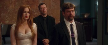 Movie still from “Keeping Up with the Joneses” (2016), directed by Greg Mottola – A group of people standing next to each other in a room; Medium shot, Over the shoulder angle