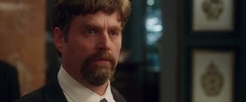 Movie still from “Keeping Up with the Joneses” (2016), directed by Greg Mottola – A person wearing a suit and tie; Close Up shot, Over the shoulder angle