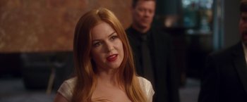 Movie still from “Keeping Up with the Joneses” (2016), directed by Greg Mottola – A woman with long red hair standing next to a man in a black suit; Close Up shot, Over the shoulder angle