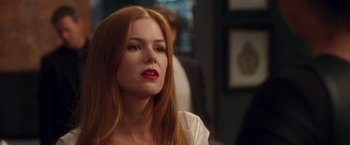 Movie still from “Keeping Up with the Joneses” (2016), directed by Greg Mottola – A woman with long red hair wearing a white top; Close Up shot, Over the shoulder angle