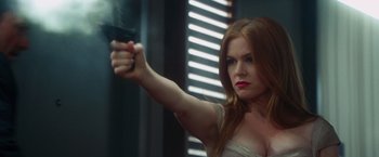 Movie still from “Keeping Up with the Joneses” (2016), directed by Greg Mottola – A beautiful woman holding a gun in her hand; Close Up shot, Over the shoulder angle