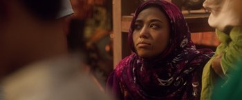 Movie still from “Keeping Up with the Joneses” (2016), directed by Greg Mottola – A woman wearing a head scarf and looking at the camera; Close Up shot, Over the shoulder angle