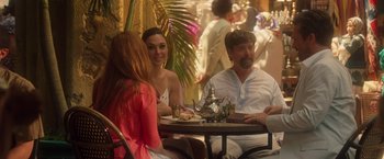 Movie still from “Keeping Up with the Joneses” (2016), directed by Greg Mottola – A group of people sitting at a table with a teapot; Medium shot, Over the shoulder angle