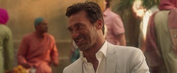 Movie still from “Keeping Up with the Joneses” (2016), directed by Greg Mottola – A person wearing a suit and smiling; Close Up shot, Over the shoulder angle